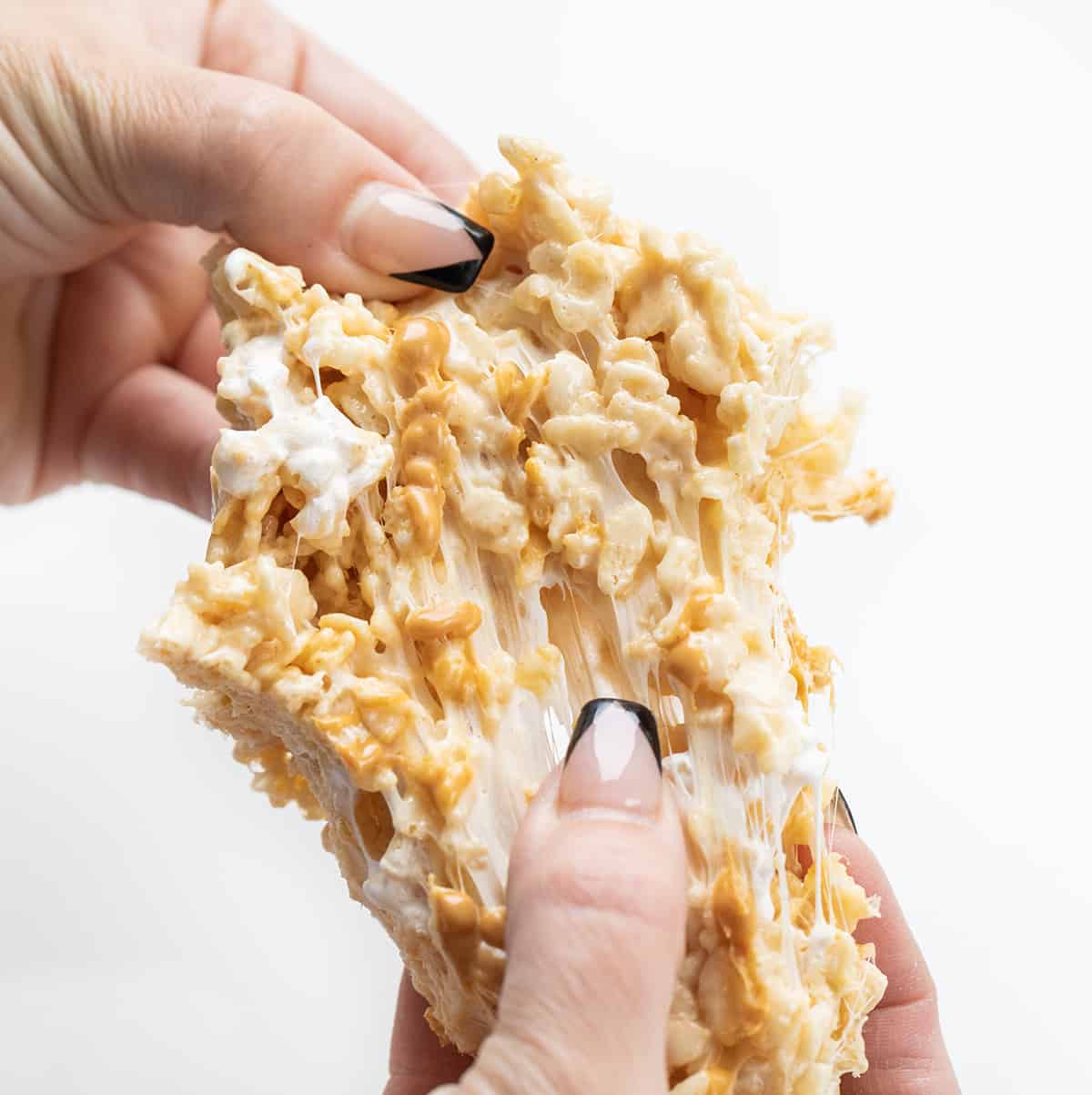 Hands Pulling Apart a Soft Fluffernutter Rice Krispie Bar.