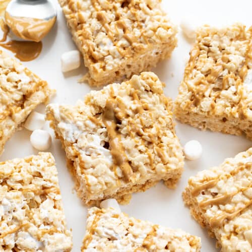 Fluffernutter Rice Krispie Bars Set out on a White Counter with Marshmallows and Peanut Butter.