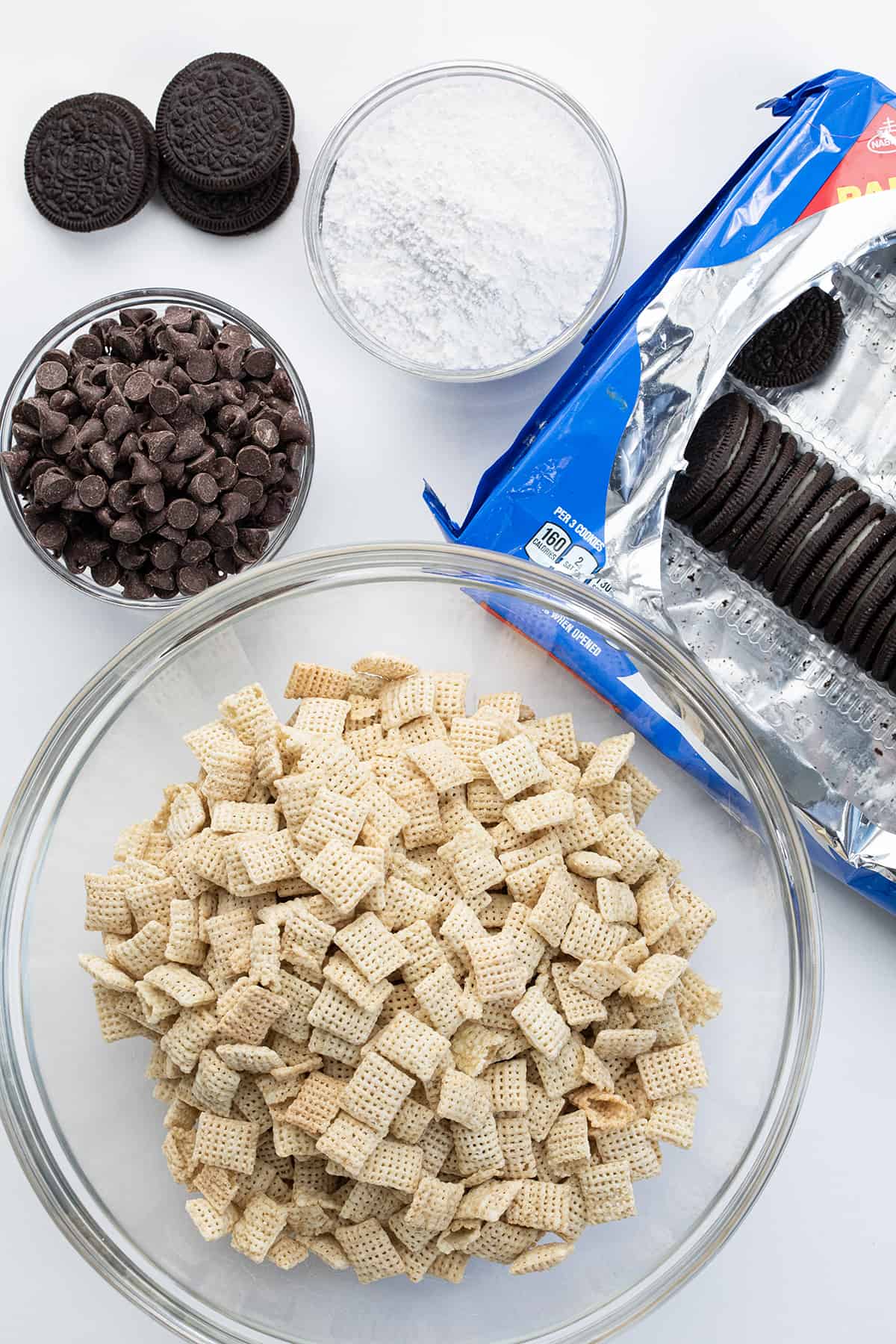Ingredients Used to Make Cookies and Cream Puppy Chow with Cereal, Oreos, Chocolate, and Confectioners Sugar