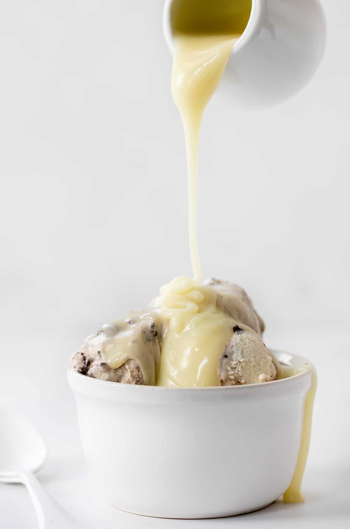 Pouring White Chocolate Ganache Over Oreo Ice Cream.