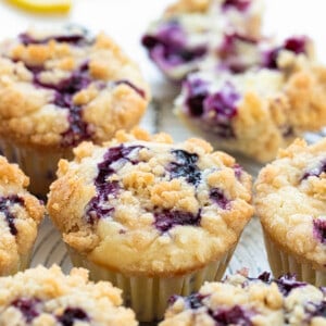 Blueberry Lemon Muffins on a White Counter with Fresh Lemon Slice and Blueberries.