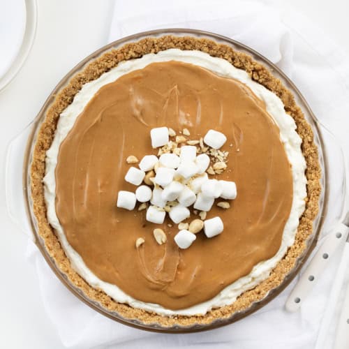 Whole Fluffernutter Pie From Overhead on a White Counter with White Plates.