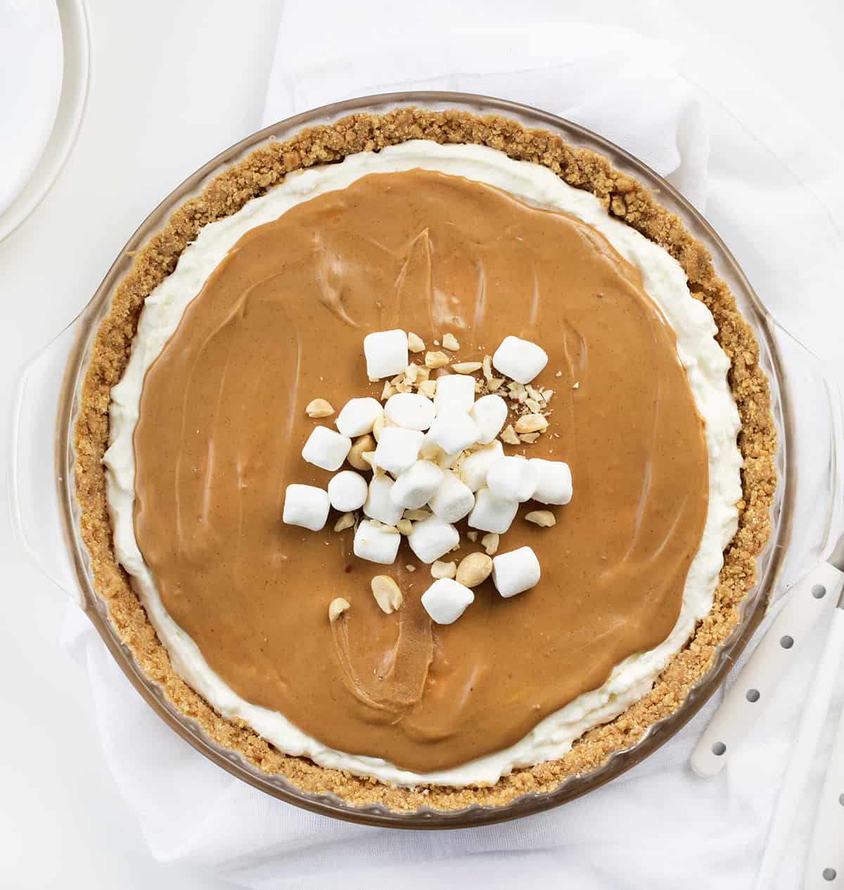 Whole Fluffernutter Pie From Overhead on a White Counter with White Plates.