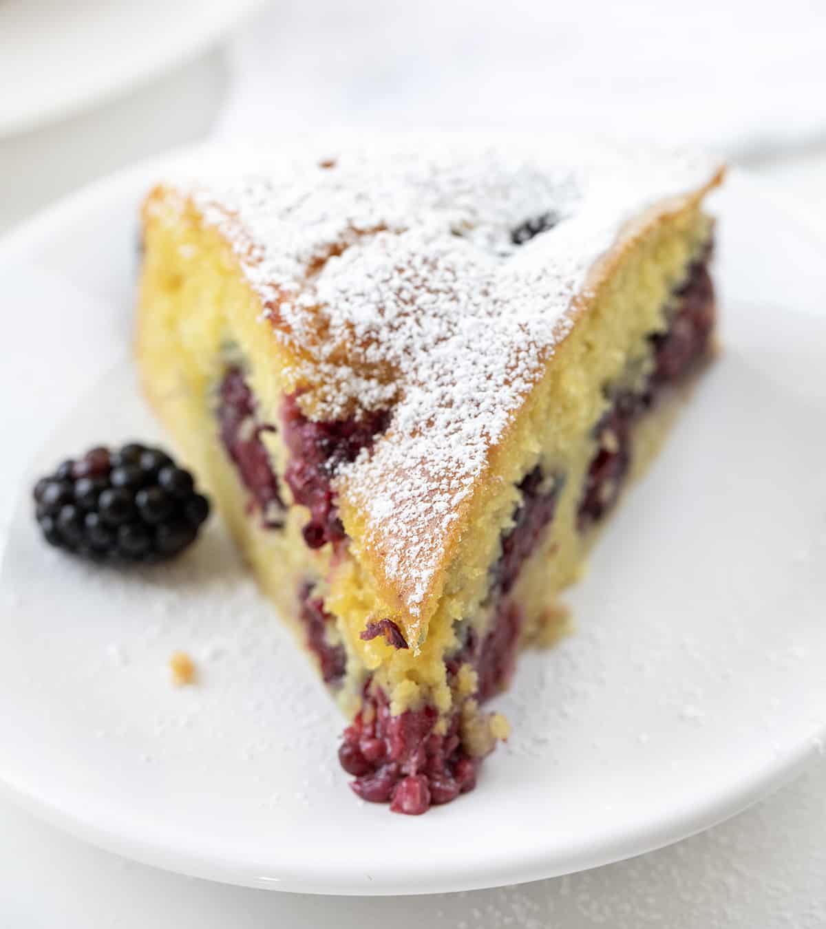 Piece of Blackberry Breakfast Cake on a White Plate with Fork.