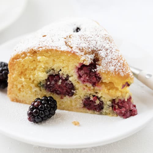 Piece of Blackberry Breakfast Cake on a White Plate with Fork.