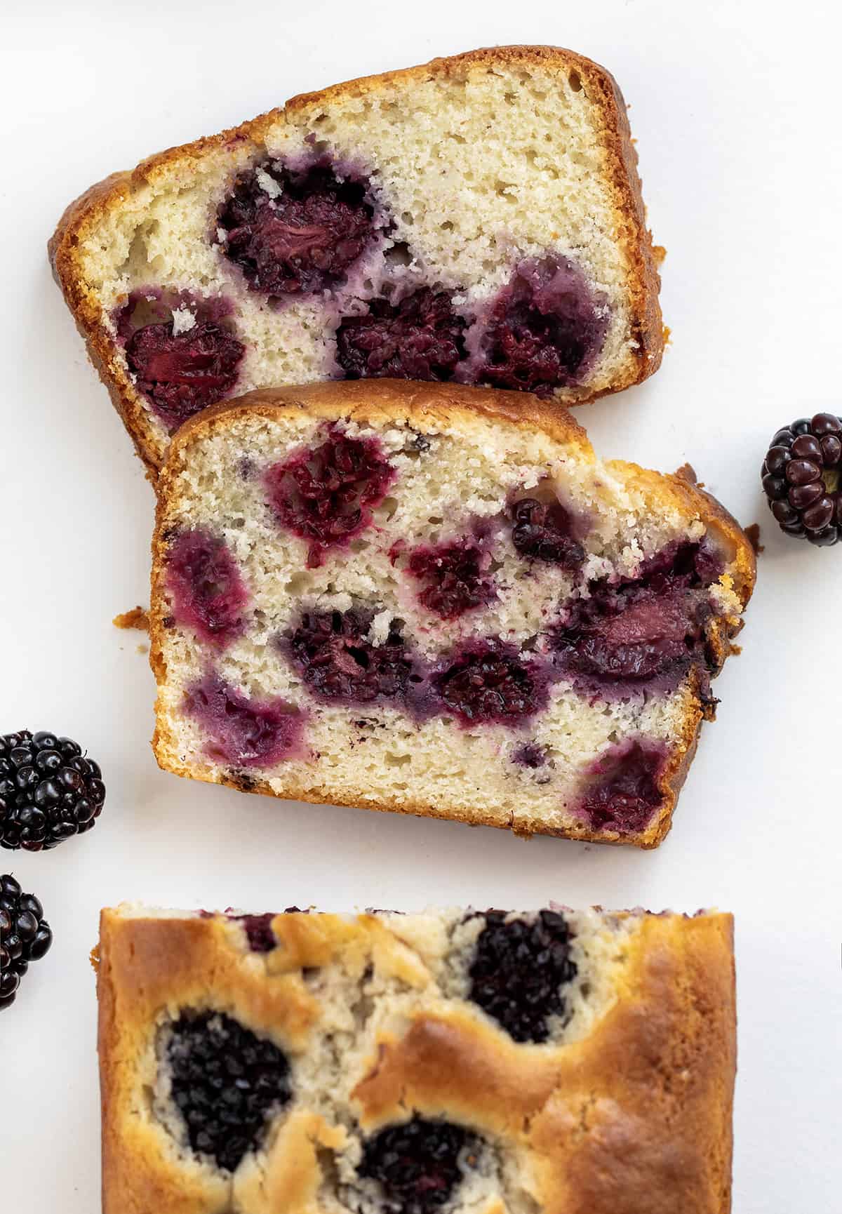 Piece of Blackberry Loaf Cut off and Laying Flat on a White Counter.