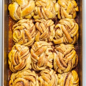 Braided Cinnamon Rolls After Baking in a Pan from Overhead on a White Counter.