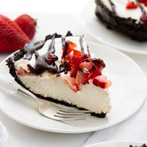 White Plates with Chocolate Strawberry Marshmallow Pie on Them with a Fork and Strawberries.