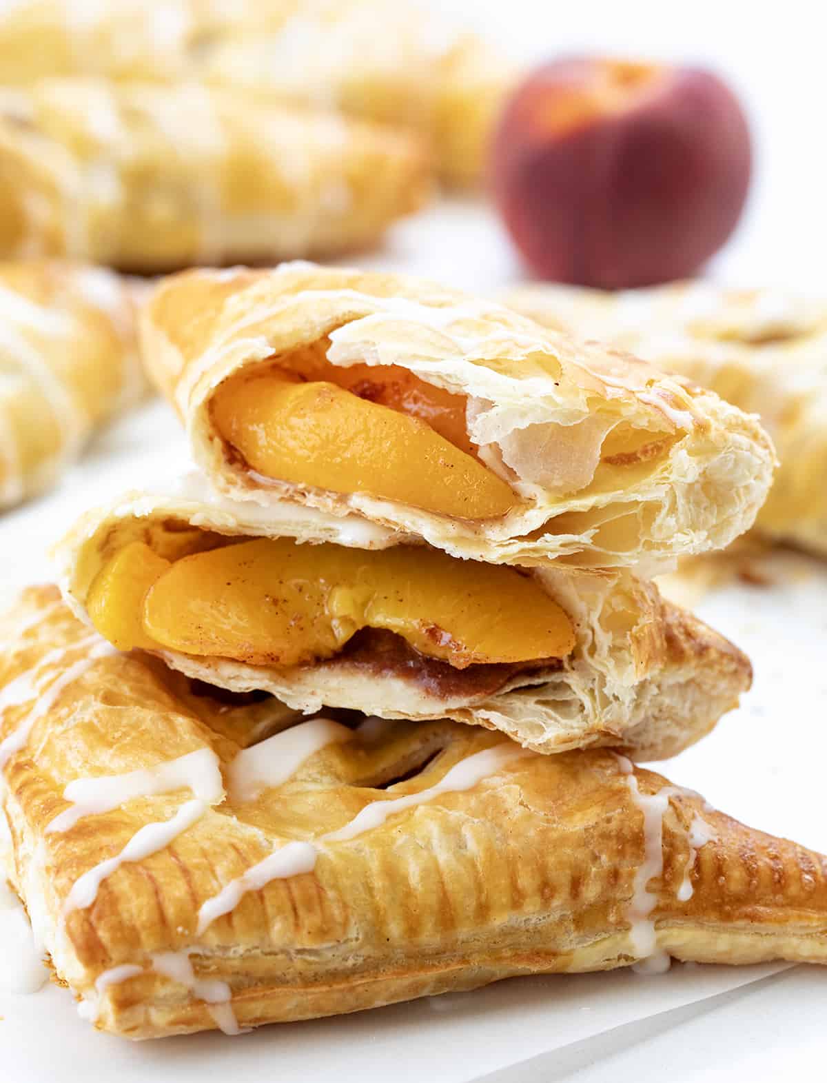 A Peach Turnovers Torn in Half Showing Peaches Inside.