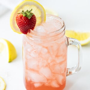 Glass Mug with Whiskey Strawberry Lemonade and a Strawberry and Lemon Garnish.