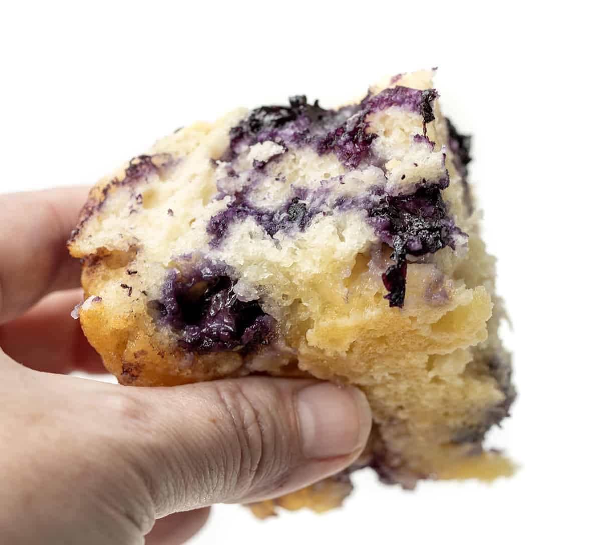 Hand Holding Blueberry Butter Swim Biscuit and Showing the Bottom Soaked in Butter.