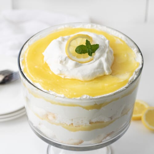 Lemon Cream Trifle on a White Counter with Plates and Lemons.