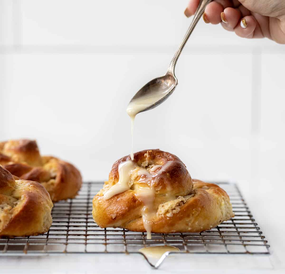 Adding Glaze to Ring A Ling Pastry on a Cooling Rack.