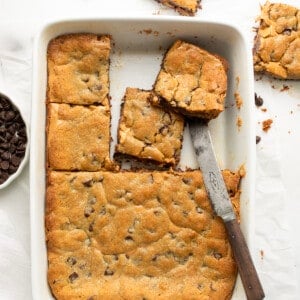 Peanut Butter Chocolate Chip Cookie Bars in a White Pan from Overhead with Some Bars Cut and Removed.