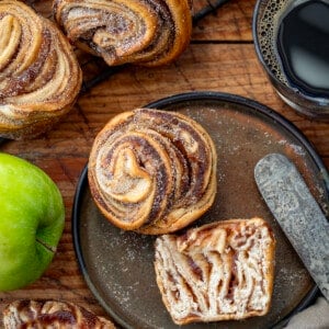 Apple Butter Cruffins on a Table with an Apple, Apple Butter, a knife, and Coffee.