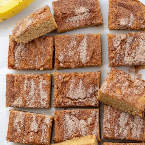 Banana Snickerdoodle Bars on a White Counter with a Banana.