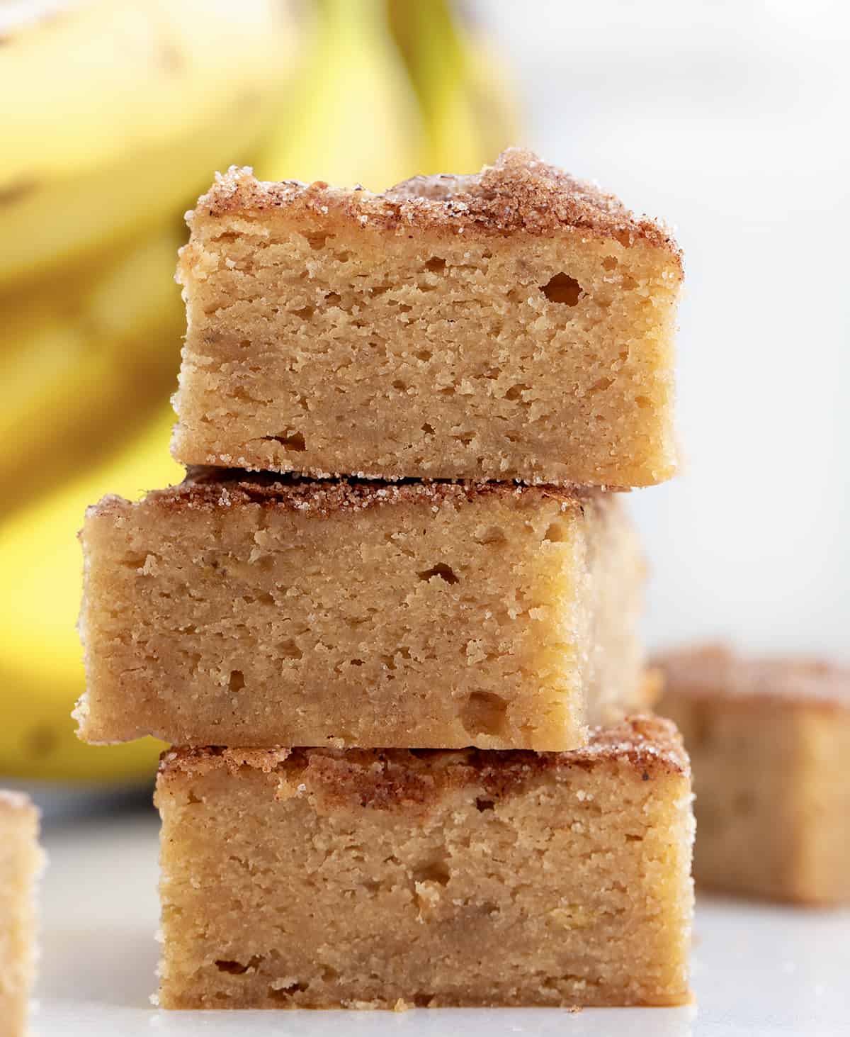Stack of Banana Snickerdoodle Bars in Front of Bananas.