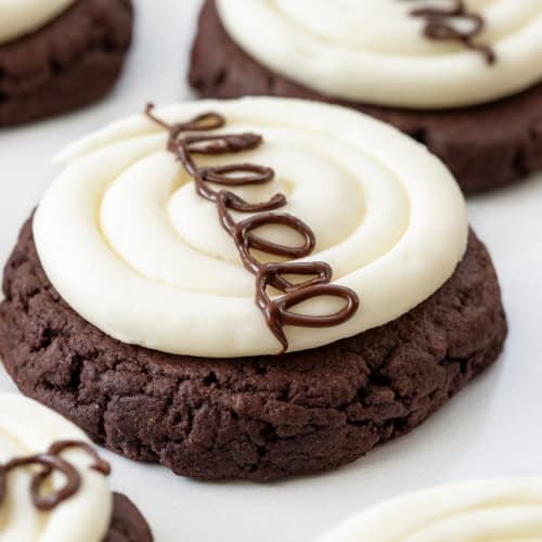 Very Close up of a Marshmallow Dream Cookie Which is a Chocolate Cookie with Marshmallow Buttercream and a Chocolate Hostess Swirl Line.