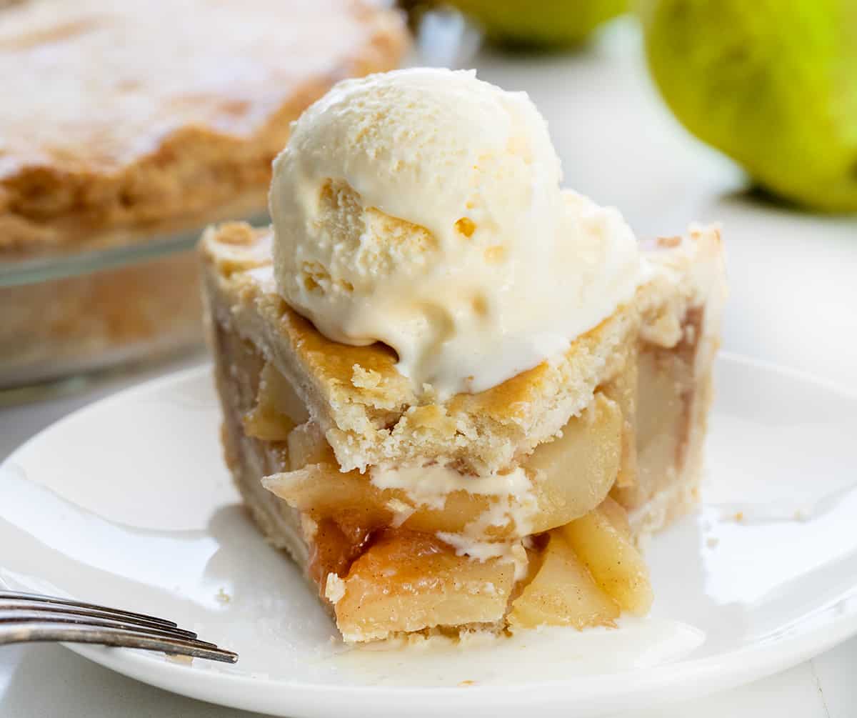 Slice of Pear Pie with a Bite Removed on a White Plate with Fork.