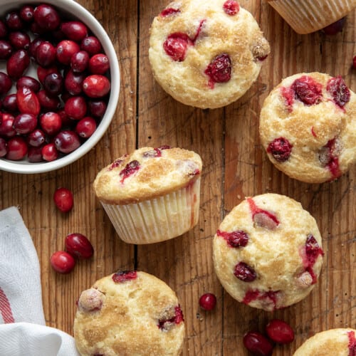 Cranberry Orange Muffins on a Table Next to Cranberries from Overhead.