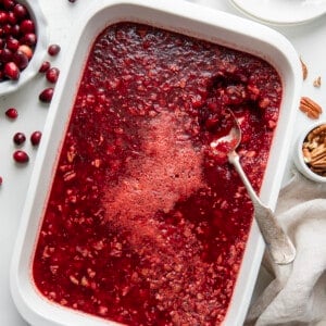 Pan of Cranberry Jello Salad with a spoon in it.