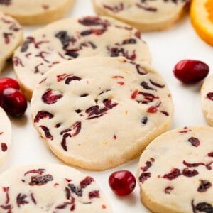 Close up of Cranberry Orange Shortbread Cookies with fresh cranberries and orange slices.
