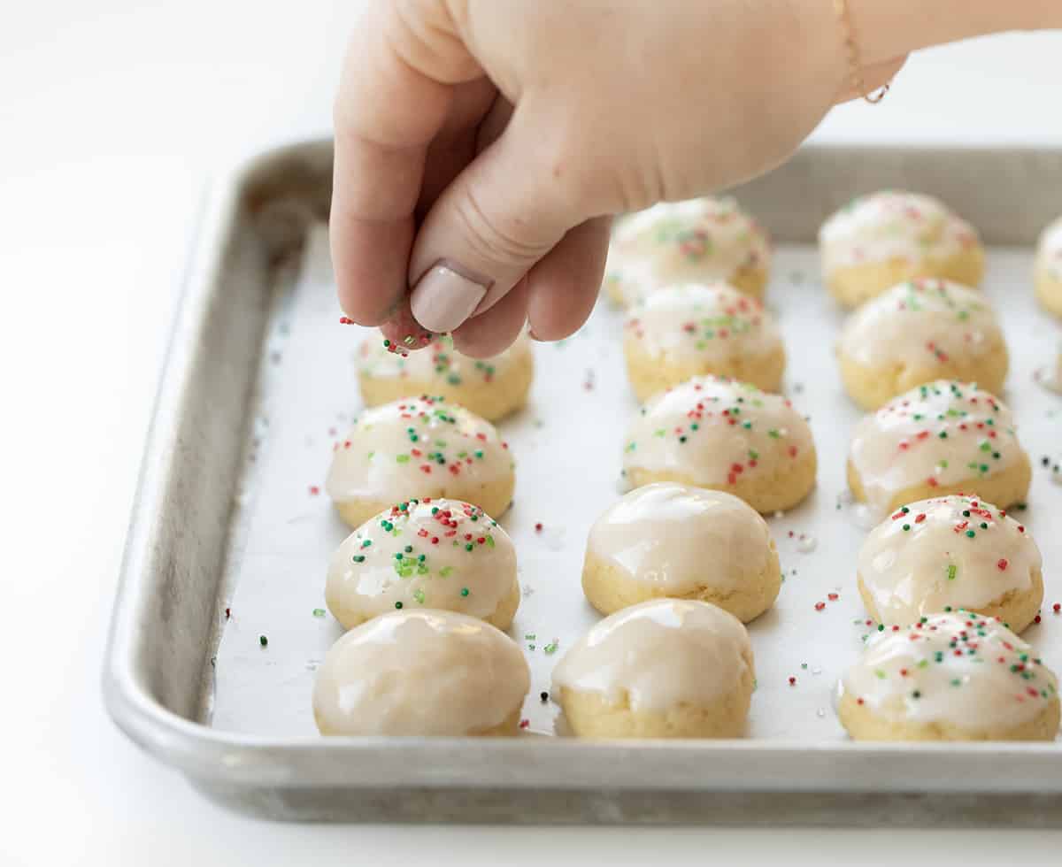 Sprinkles going on Italian Christmas Cookies.