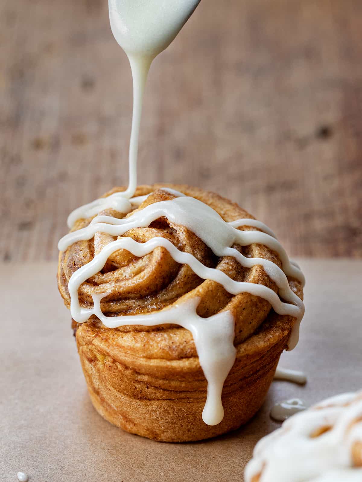 Drizzling cream cheese glaze over Pumpkin Spice Cruffins.