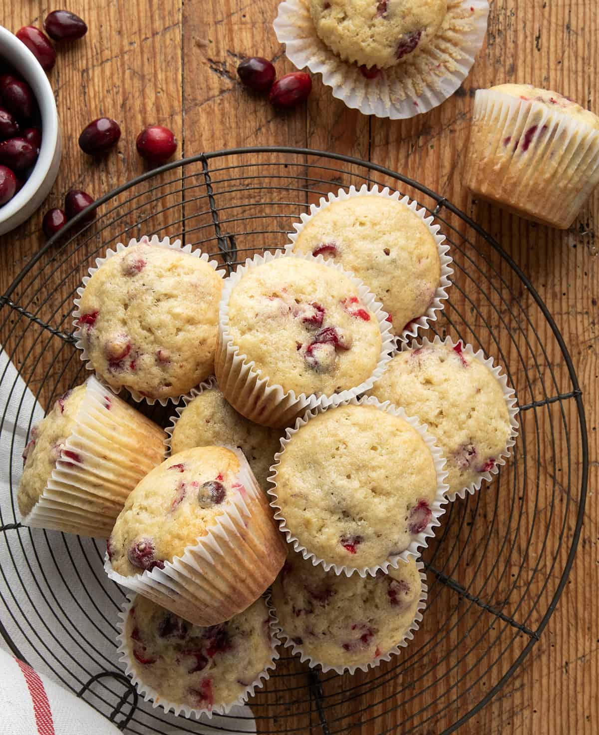 Cranberry Banana Muffins on a rack on a wooden table from overhead.