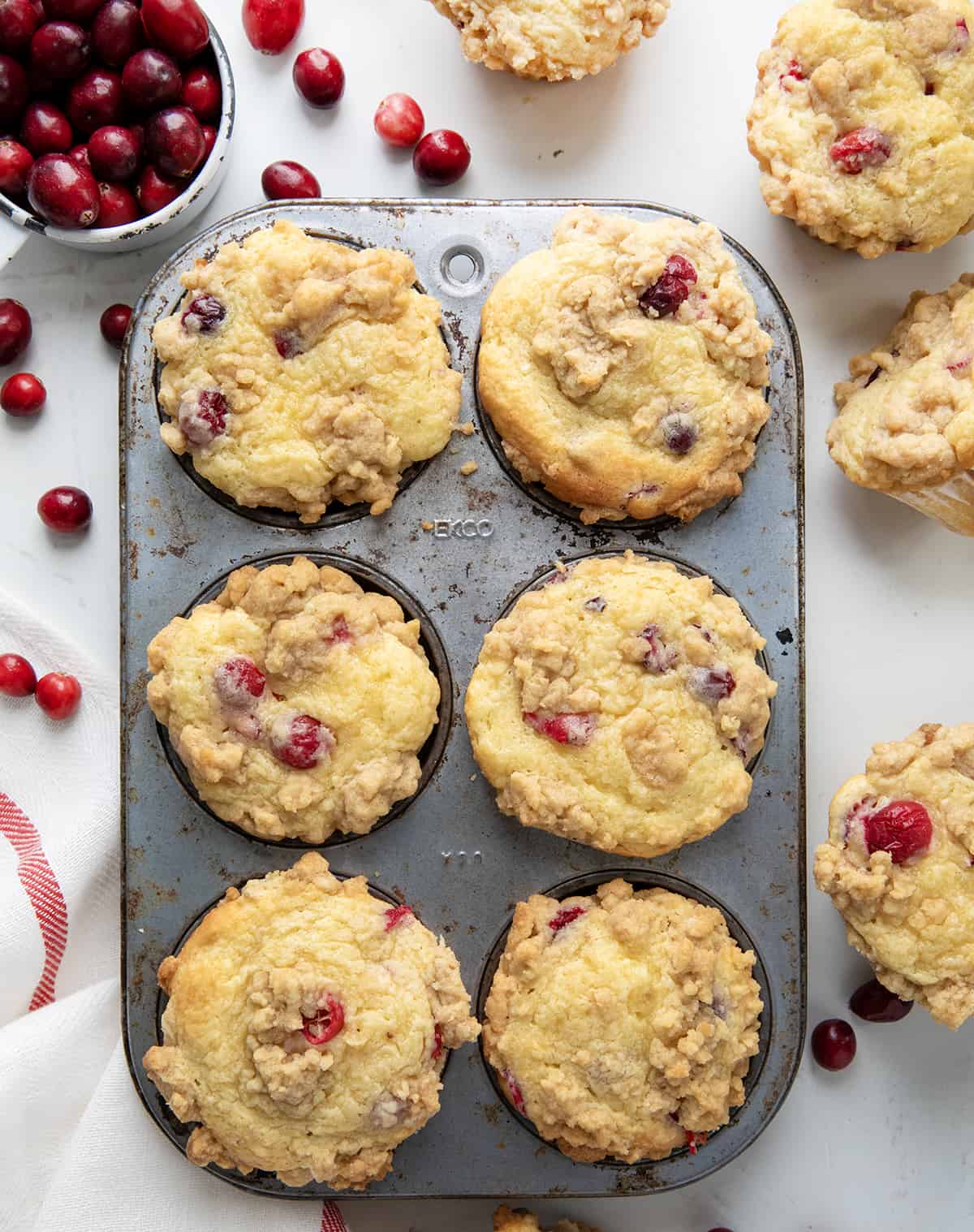Cranberry Cream Cheese Muffins in a muffin tin on a white table from overhead.