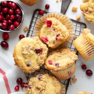Cranberry Cream Cheese Muffins on a cooling rack on a white table from overhead.