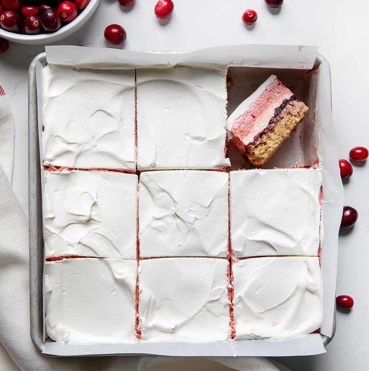 Pan of Cranberry Delight with pieces cut and one piece on its side. 