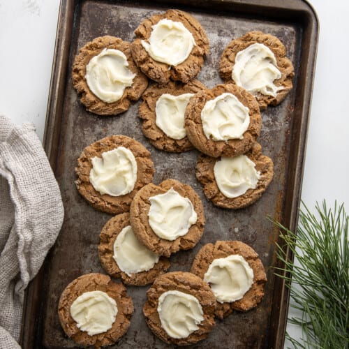 Gingerbread Thumbprint Cookies on a cookie sheet on a white counter.