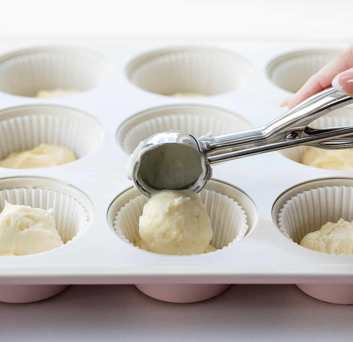 Adding cream cheese to lemon muffin batter.