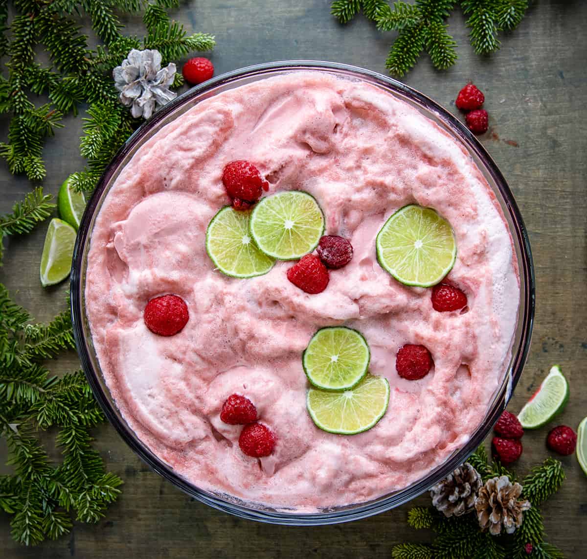 Sherbet Christmas Punch Bowl on a table with lime and raspberry.