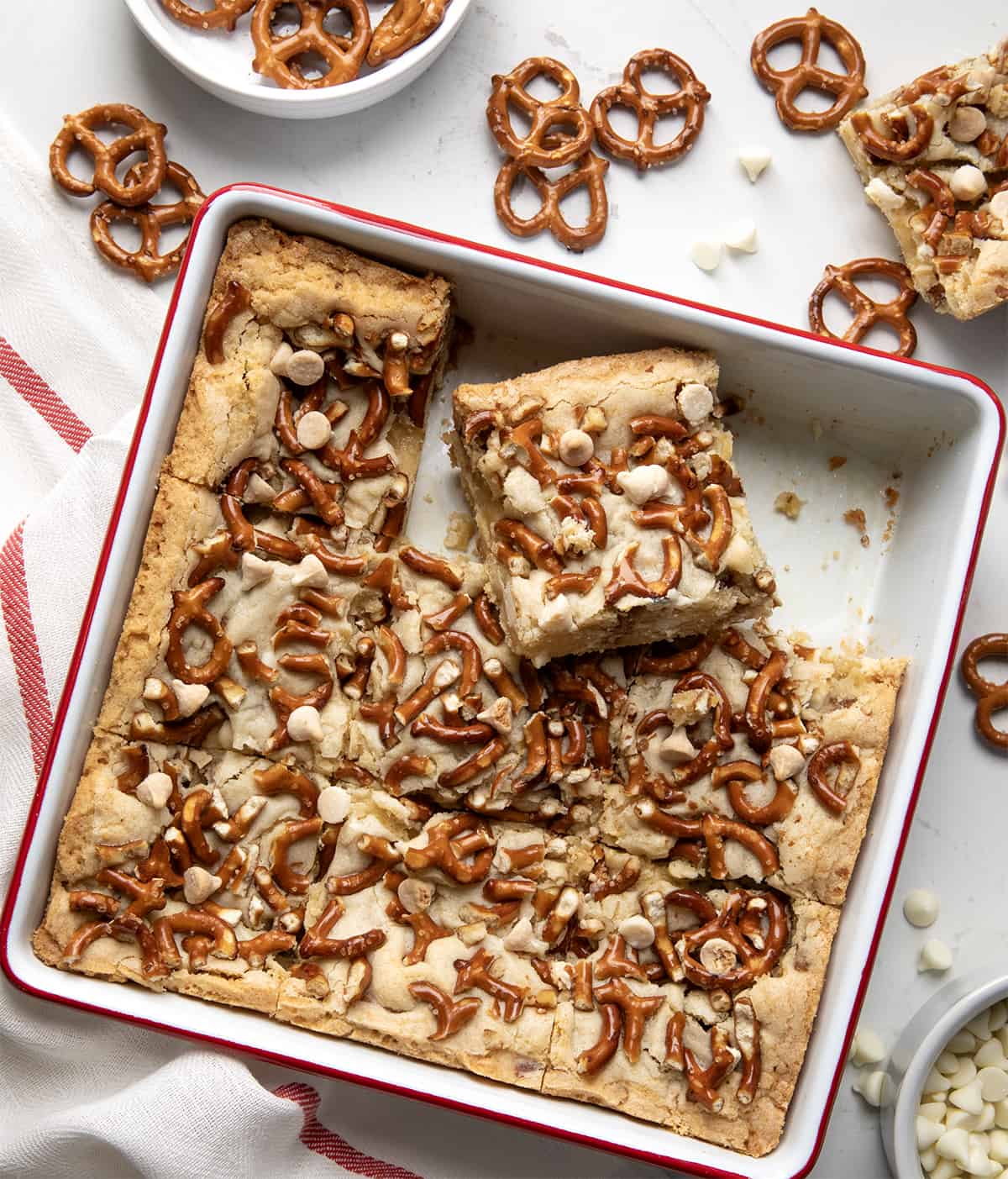 Pan of White Chocolate Pretzel Blondies cut up and one removed. 