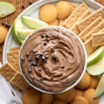 Bowl of Brownie Batter Dip on a platter with apples and cookies.