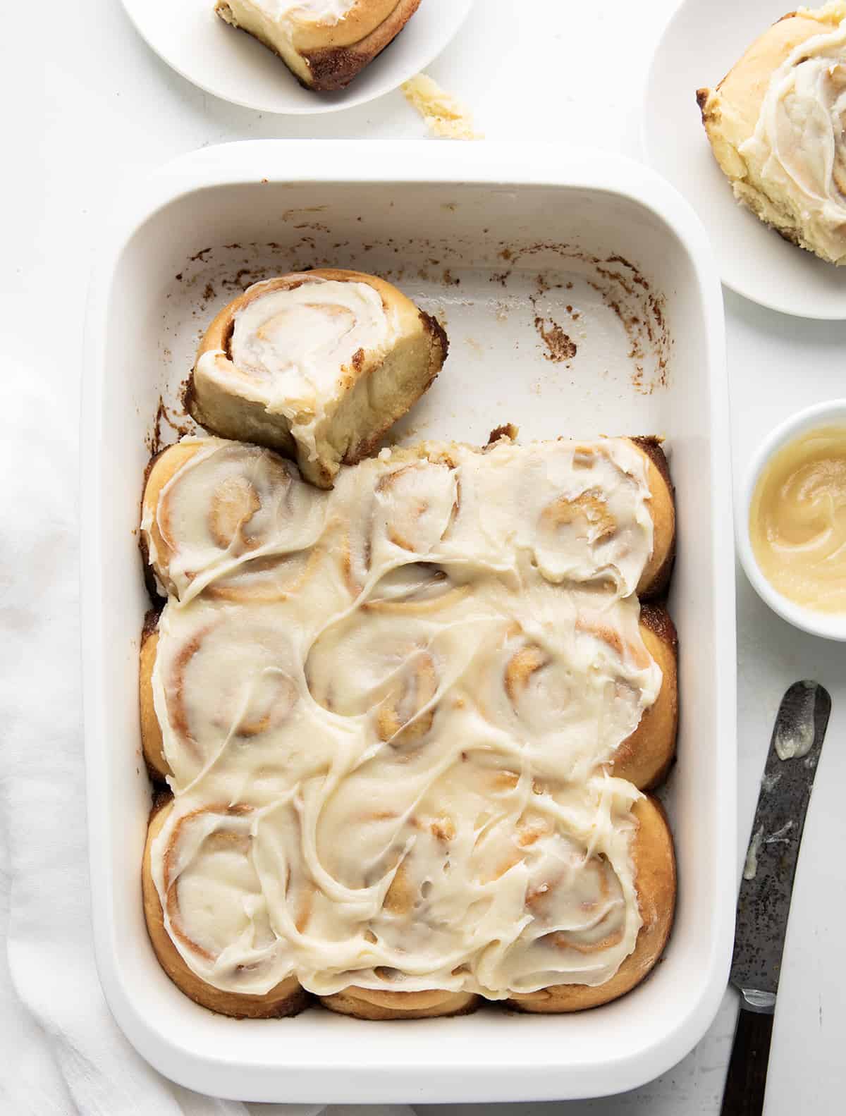 Gingerbread Cinnamon Rolls in a pan on a white counter. 