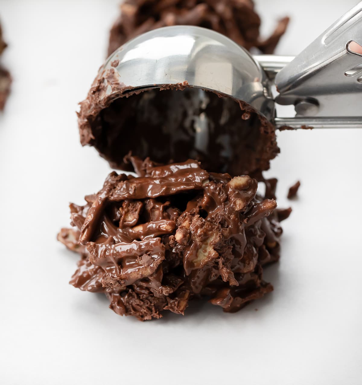 Scooping Chocolate Haystacks onto parchment paper.