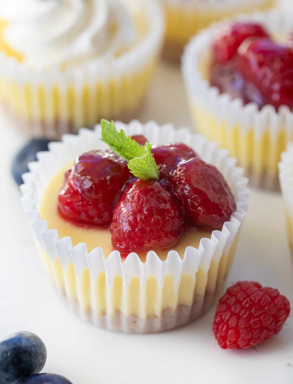 Close up of Mini Cheesecake with raspberry pie filling on top.