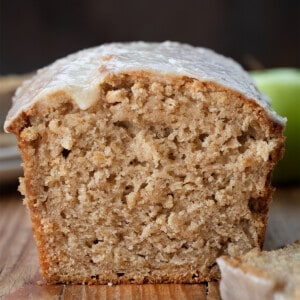 Loaf of Applesauce Bread cut showing inside texture on a wooden table.