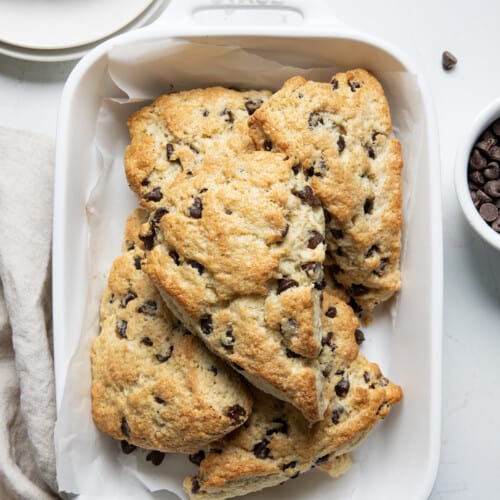 Chocolate Chip Scones in a white dish on a white counter.