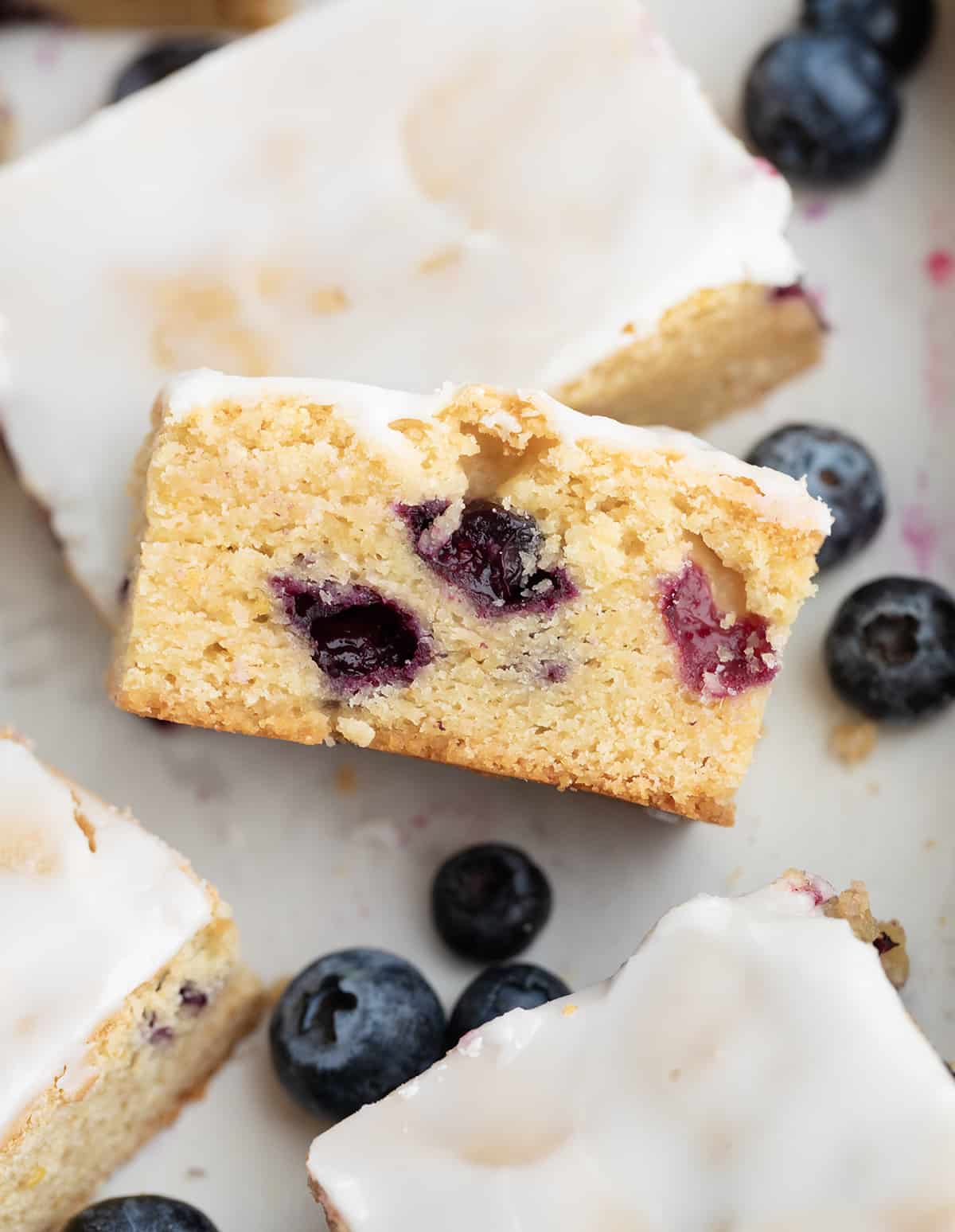 Close up of a cut Lemon Blueberry Blondie surrounded by more blondies.