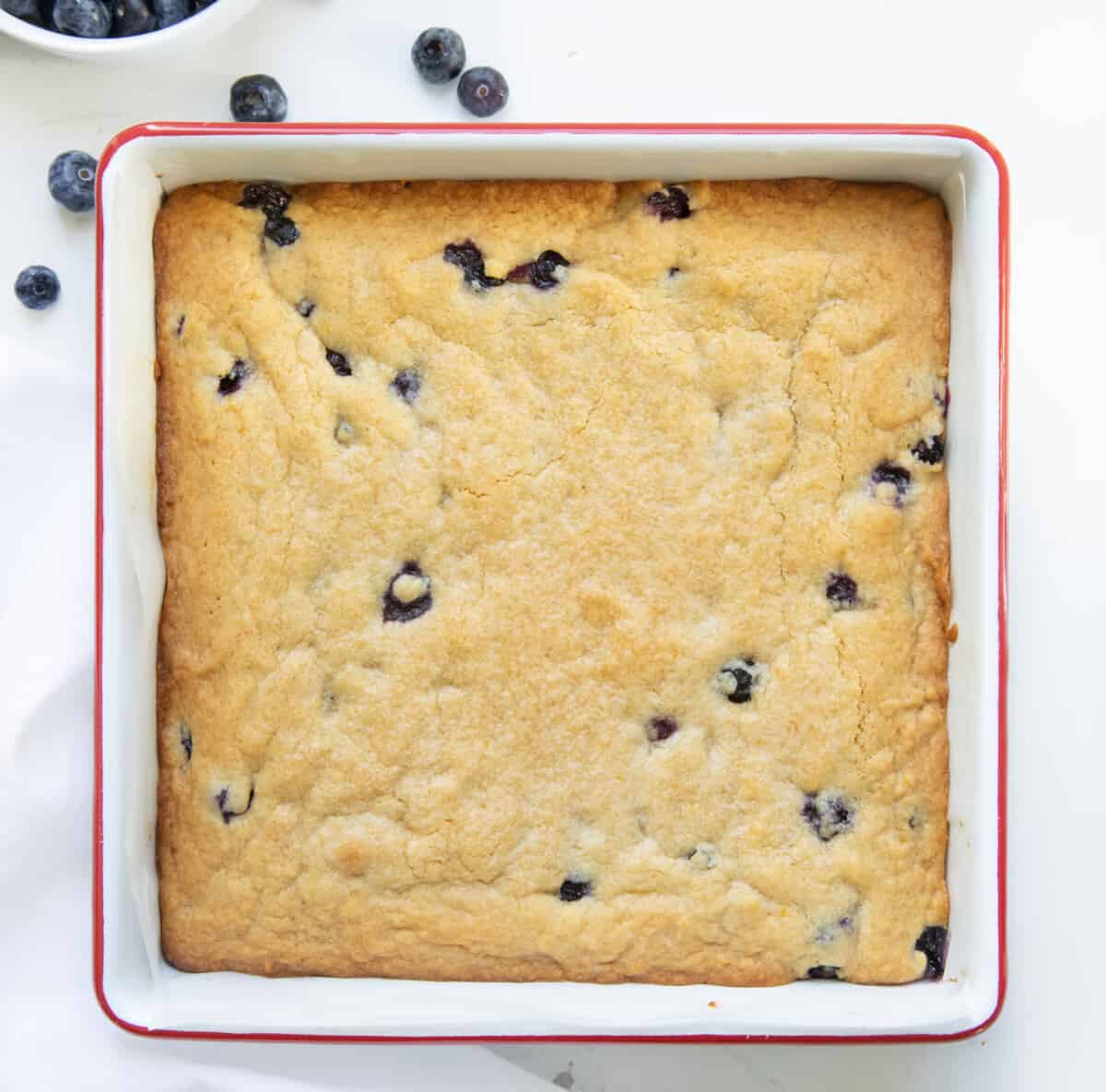 Pan of Lemon Blueberry Blondies on a white table from overhead.