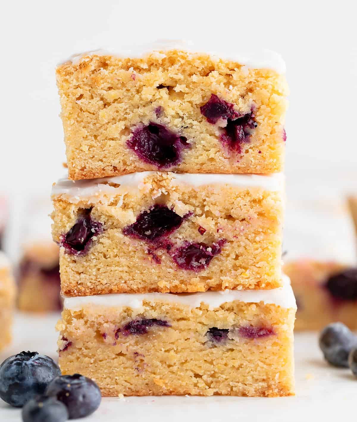 Stack of Lemon Blueberry Blondies on a white surface.