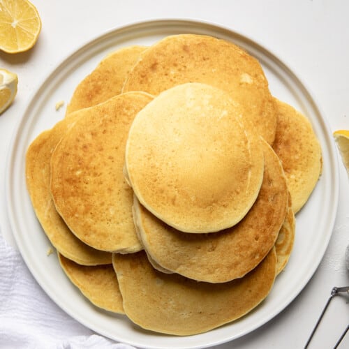 Plate of Lemon Ricotta Pancakes on a white table from overhead.
