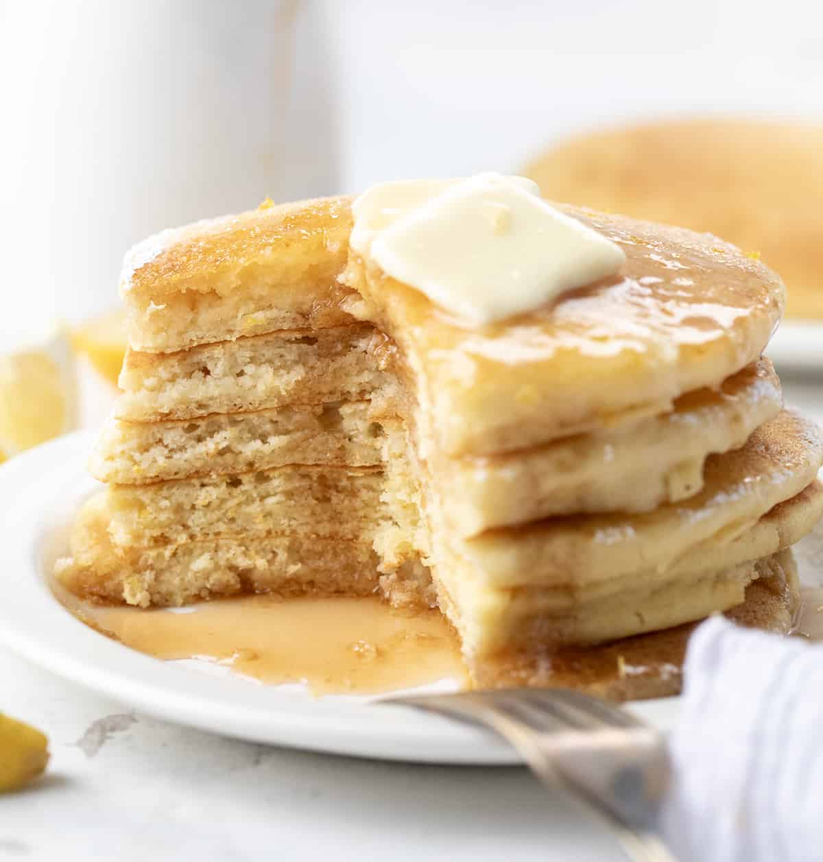 Stack of Lemon Ricotta Pancakes cut into showing inside texture.