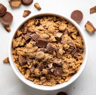 Bowl of Edible Peanut Butter Cookie Dough with reeses peanut butter cups around it.