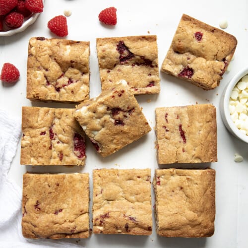 Raspberry White Chocolate Blondies cut into squares on a white counter from overhead.
