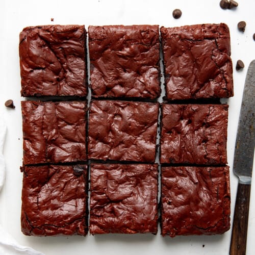 Red Velvet Brownies on a white table cut into squares from overhead.